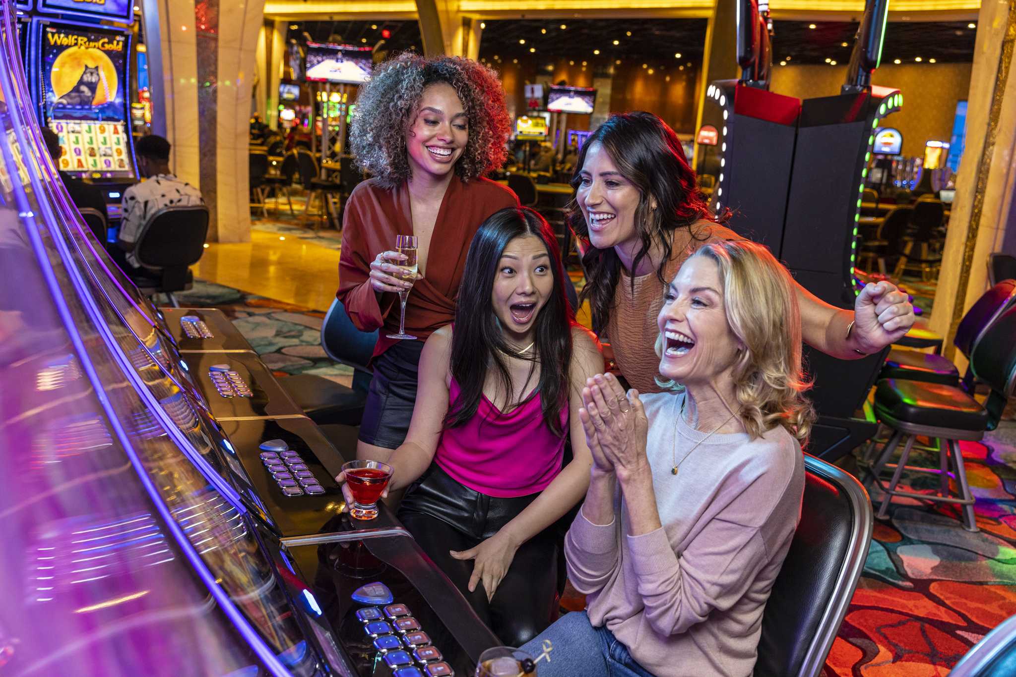 A few friends having a good time playing Slot Machines.