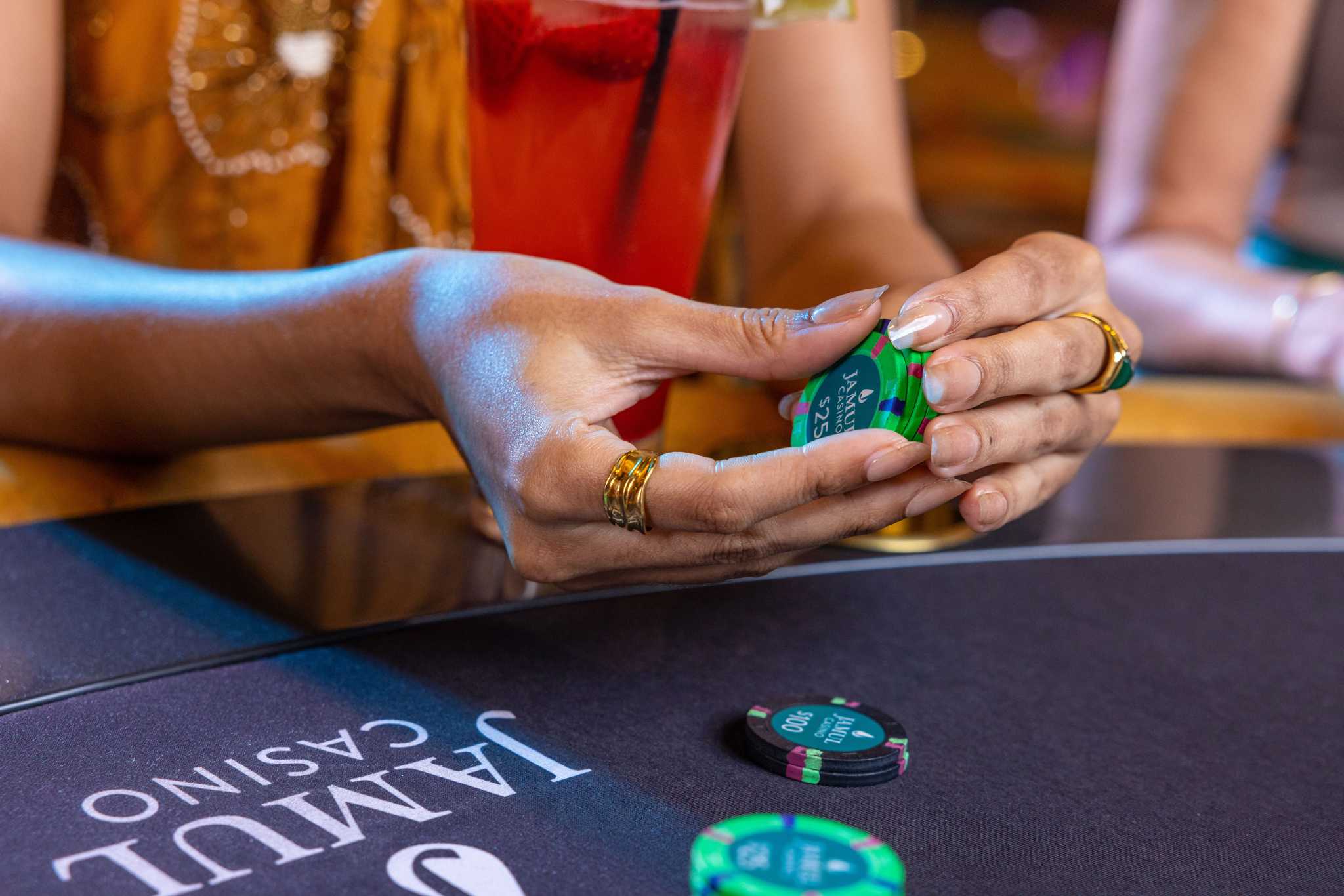 A closeup of a visitor's hands holding poker chips and having fun playing games in Jamul Casino.
